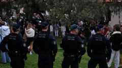 Police stand guard as mourners gather at a tribute at the Bondi Pavilion in memory of the victims of a shooting at Bondi Beach, in Sydney on Dec. 16.