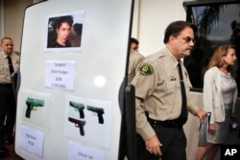 FILE- This May 24, 2014, photo shows Santa Barbara County Sheriff Bill Brown, right, after a news conference as he walks past a board showing photos of gunman Elliot Rodger and the weapons he used in a mass shooting the day before in Isla Vista, Calif. Authorities later concluded after an investigation that Rodger, who killed six people and injured 14 others, then killed himself, had acted alone.