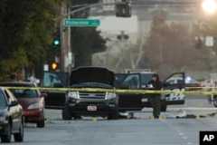 An investigator looks at a black SUV that was involved in a police shootout with suspects, Dec. 3, 2015, in San Bernardino, California.