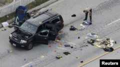 A law enforcement officer looks over the evidence near the remains of a SUV involved in the Wednesdays attack is shown in San Bernardino, California, Dec. 3, 2015.