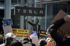 Protest against Elon Musk and DOGE cuts to government funding in front of a Tesla showroom in NYC.