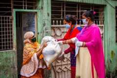 Development workers hand over relief aid to a woman amid the COVID-19 pandemic in Dhaka, Bangladesh. Development workers hand over relief aid to a woman amid the COVID-19 pandemic in Dhaka, Bangladesh.