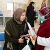 A health worker provides COVID-19 information to a patient visiting the Jerusalem Health Center. A health worker provides COVID-19 information to a patient visiting the Jerusalem Health Center.