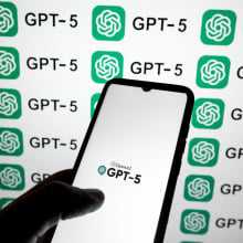 The OpenAI GPT-5 logo appears on a smartphone screen and as a background on a laptop screen in this photo illustration in Athens, Greece, on August 7, 2025.