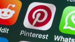 The buttons of the app Pinterest, surrounded by Reddit, Whatsapp, Skype and other apps on the screen of an iPhone.