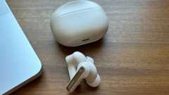 cream colored anker soundcore life p3i headphones and case next to laptop