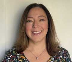 a woman wearing a flower pattern shirt smiling