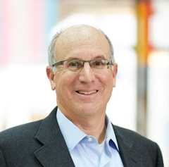 a man wearing a black suit smiling