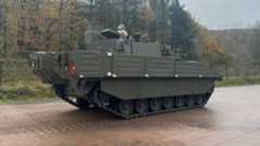 The green Ajax armoured vehicle. A soldier can be seen stationed at the top of the vehicle.