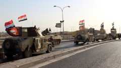 A convoy of Iraqi military trucks flying religious Shiite flags and Iraqi national flag as they advance into the central of Kirkuk city, northern Iraq