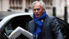 Samir Shah in a suit and bright blue scarf arriving for the committee hearing