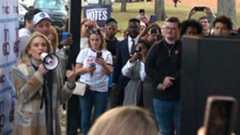 The Democratic candidate canvasses with a loudspeaker, with people around her taking pictures