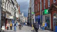Strand Street, a pedestrianised shopping street with a lot of people walking on a clear day.