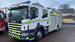 A parked white fire engine with fluorescent green stripes on it