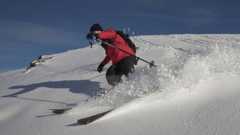 A man skiing in a red jacket