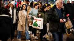 A damp sidewalk in New York City being crossed by men and women carrying shopping bags.