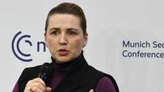 Danish Prime minister Mette Fredericksen mid speech. She's holding a mic in her right hand