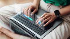 Female hand interacting with virtual interface while managing online security system with laptop - stock photo