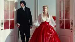 Jacob Elordi in a black suit as Heathcliff and Margot Robbie as Cathy in a white and red PVC dress