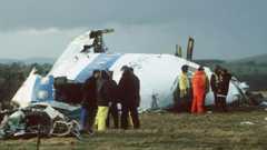 Rescue workers stand next to the wreckage of Pan Am flight 103 in Lockerbie, Dumfries and Galloway in December 1988.
