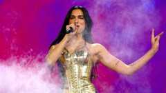 Popstar Dua Lipa, dressed in a gold outfit, performs onstage at Madison Square Garden surrounded by a white mist