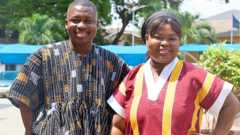 A man and a woman in fugus outside the office's of Ghana's National Health Insurance Scheme (NHIS) in Accra, Ghana.