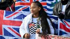 A woman wearing a t-shirt bearing the flag of the British Indian Ocean Territory takes part in a protest against the UK-Mauritius Chagos Islands deal outside the UK Parliament in January 2026.