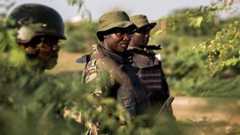 A group of three Kenyan soldiers in camouflage and flak jackets stand amid a green background.