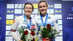 Sophie Capewell and Emma Finucane smiling with medals around the necks and holding flowers