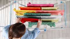 Woman using airer to dry clothes