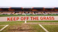 A general view inside Vale Park of mud on the pitch and a 'keep off the grass' sign