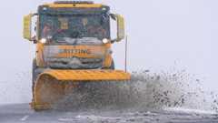 A snow plough keeps road clear as snow falls on the North Yorkshire moors in February