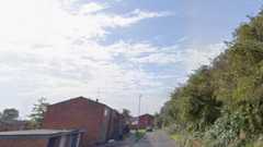 Houses on one side of the road, with trees on the other side of the road
