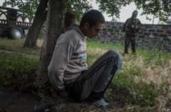 A rebel gunman guards suspected looters in Sloviansk, eastern Ukraine (12 June 2014)