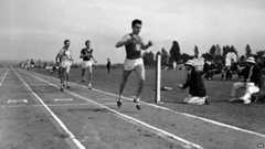 Louis Zamperini of he University of Southern California, breaks the tape and record with a time of 4:16.3 to win the mile run in the Pacific Coast Conference Track and Field meet the University of Washington Stadium in Seattle 20 May 1939