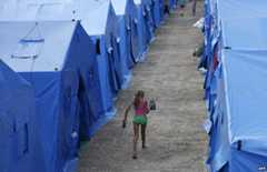 Girl carrying kettle at refugee camp, Simferopol