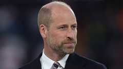 Prince William in a dark suit with white shirt and striped tie