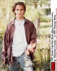 James Van Der Beek, as Dawson Leery, appears standing in a field with a hand in his jeans pocket, wearing a white t-shirt and red plaid long-sleeved buttoned-down shirt