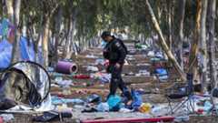 An Israeli security officer inspects the scene of the 7 October attack by Hamas gunmen on the Nova music festival in Reim, Israel (17 October 2023)