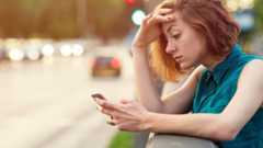 A young woman looks at her phone