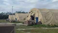 A low-resolution photo showing three large khaki tents used to house migrants on Diego Garcia