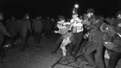 A vocal protest by a female hippy while being taken away by police at Amesbury, close to Stonehenge in June 1989