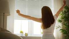 Morgens macht eine Frau Dehnübungen.