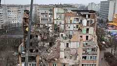 Des secouristes dégagent les décombres d'un immeuble résidentiel fortement endommagé par une frappe russe à Ternopil, en Ukraine, le vendredi 21 novembre 2025.