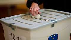 Une électrice glisse son bulletin dans l'urne lors du référendum sur l'aide à mourir pour les patients en phase terminale, à Domzale, en Slovénie, le 23 novembre 2025.