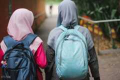 Two girls with hijabs walking down a path