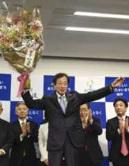 神戸市長選で4選を果たし、花束を掲げる久元喜造氏=26日夜、神戸市中央区