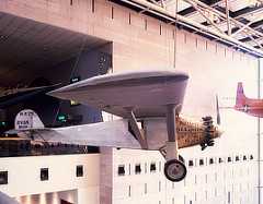 Color photo shows the airplane in profile as it hangs from the museum ceiling.