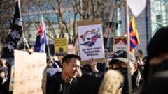 Protesters in London hold up signs opposing China's transnational repression.