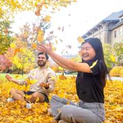 Cornellians playing with leaves on the university's Ag Quad.